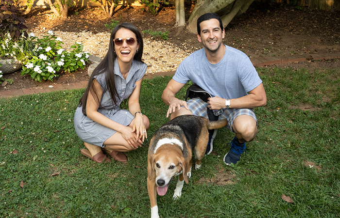 Couple smiling with their dog.